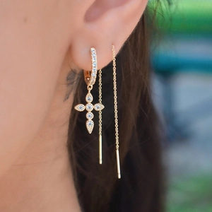 Close-up of gold S925 sterling silver long chain earrings with zircon cross pendant