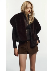 Women's winter faux mink fur vest in dark brown paired with black long-sleeve top and shorts