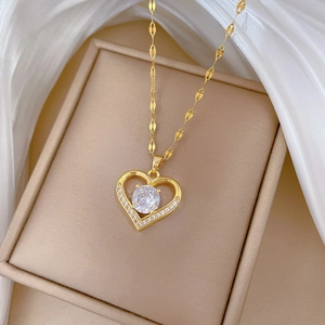 Macro shot of gold heart necklace with micro-pave crystal in a beige jewelry gift box