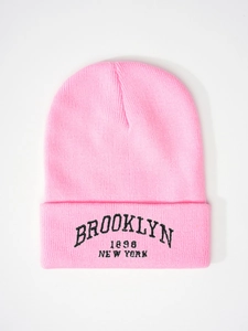 Detailed close-up of pink knit hat with black Brooklyn 1898 New York embroidery