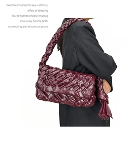 Detail of burgundy woven leather shoulder bag featuring stylish knot strap and tassels