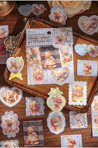 Detailed view of vintage teddy bear stickers with retro blue and brown motifs on a metal tray