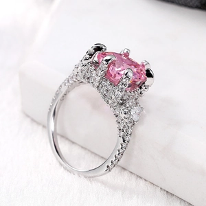 Macro side view showing pink heart zircon stone and pavé diamond setting on silver ring