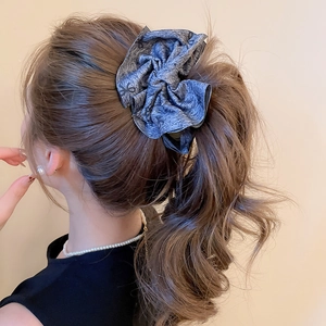 Detail of a large grey tie-dye scrunchie styled in a high ponytail for a chic look