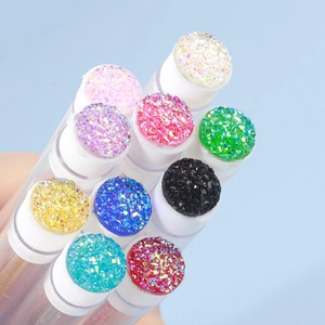 Detail of disposable eyelash brush tubes with colorful glitter caps and clear bodies