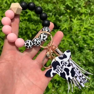 Detail of beaded keychain bracelet with Mama bull head charm and tassel held by hand