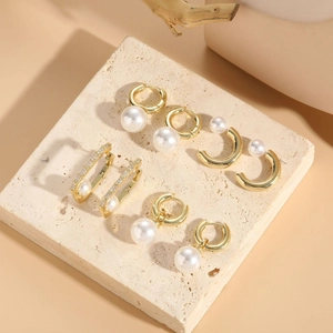 Detail shot of five pairs of 14K gold plated earrings with pearls and zircon in high quality