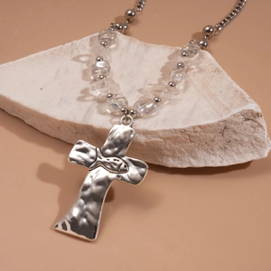 Detail of silver hammered metal cross necklace with irregular clear stone beads