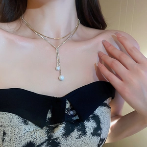 Elegant double-layered pearl and rhinestone tassel necklace shown on a model neck