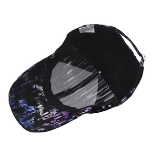 Detail view of the tie-dye pattern brim and 100% polyester label on a baseball cap