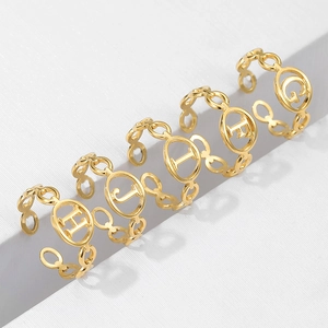 Close-up of gold stainless steel adjustable rings with letter H, J, I, F, G details