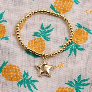 Bracelet à perles dorées avec pendentif étoile et lune serti de zircons sur tissu