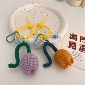 Detail of handmade crochet tulip keychains in purple and orange with colorful plastic clips
