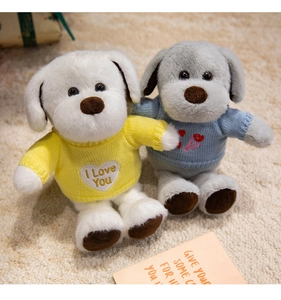 Détail de chiots en peluche avec pulls en tricot bleu et jaune et broderie en forme de cœur
