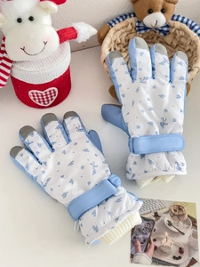 Detail of blue floral ski gloves featuring touch screen fingertips and adjustable wrist straps