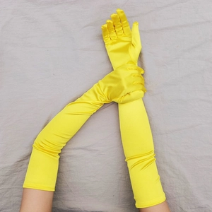 Dettaglio di guanti lunghi in raso giallo brillante con vestibilità elastica per feste 1920
