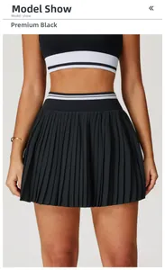 Detail view of high-waist black pleated tennis skirt with striped elastic waistband