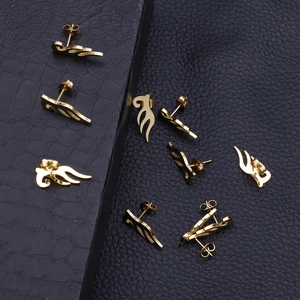 Golden stainless steel angel wing stud earrings shown in various angles on black leather