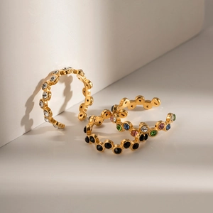 Three minimalist gold titanium steel snake rings set with colorful zircon crystals