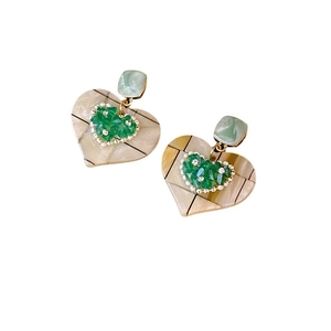 Vintage heart earrings with green beads and beige textured shell inlay on white background