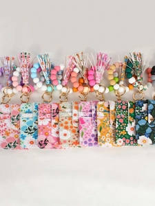 Set of floral silicone bead wristlet wallets with tassels in pink, blue and green colors