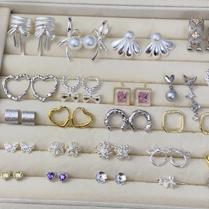 Collection of silver and gold earrings with pearls and crystals in a velvet jewelry box