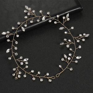Handmade gold leaf bridal headband with marquise crystals and beads on leather backdrop