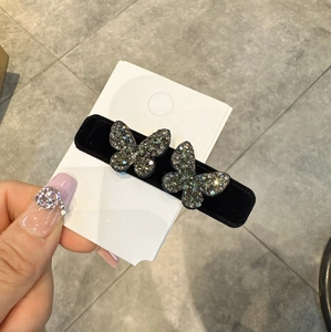 Dettaglio elegante fermaglio per capelli in velluto nero con farfalle di strass lucenti