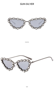 Macro detail of gunmetal cat-eye sunglasses featuring intricate rhinestone embellishments