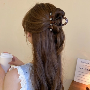 Brown acrylic hair claw with bear motifs shown in a stylish hairstyle for women