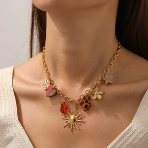Boho gold necklace with sun flower heart pendants worn by a model in warm light