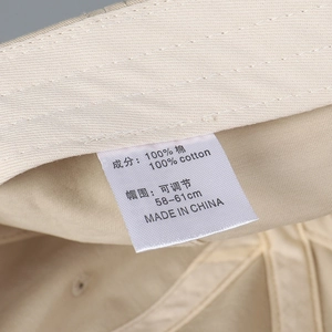 Detail of adjustable strap and 100% cotton stitching on beige baseball cap interior