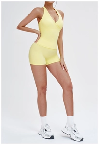 Close-up of bright yellow yoga set featuring a halter cross-back top and high-waist shorts
