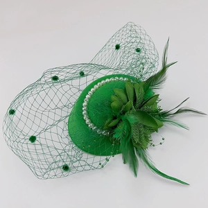 Detail of green fascinator hat with elegant mesh veil, feathers and white faux pearls