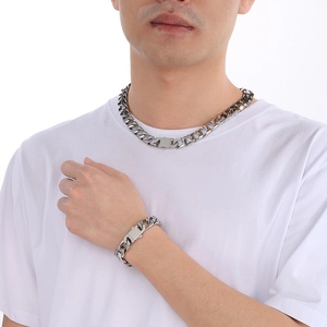 Close-up of a man wearing a 13mm silver stainless steel Cuban link necklace and bracelet set