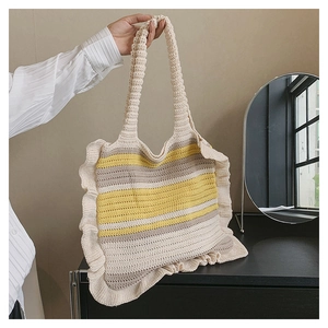 Close-up of handmade striped knit tote bag with elegant ruffle edge and cotton texture