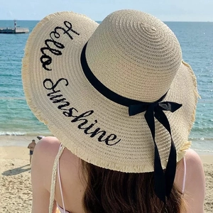 Wide brim straw sun hat with Hello Sunshine embroidery and black ribbon bow detail
