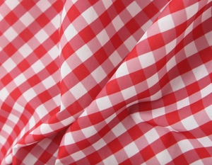 Gros plan d'un tissu en coton à carreaux rouges et blancs avec une texture douce