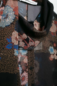 Detail of vintage chiffon shirt featuring floral paisley patterns and scarf collar design