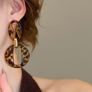 Close-up of tortoise shell resin double hoop earrings with gold metal accents