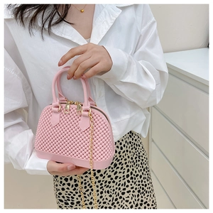 Detail of pink jelly shell bag with textured surface and golden chain strap for kids