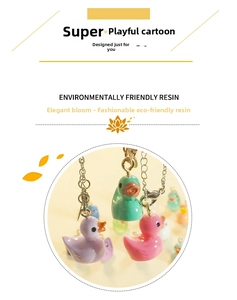 Close-up of candy-colored resin duck charms with golden lobster clasps for DIY accessories