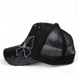 Detail of black sequins, rhinestone butterfly patch and breathable mesh on baseball cap