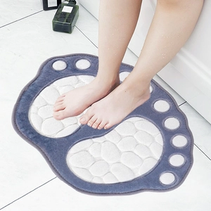 Pebble textured grey and white foot shaped non-slip microfiber bath mat on tiled floor