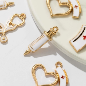 DIY medical charm set with gold syringe, stethoscope, and nurse hat for jewelry making