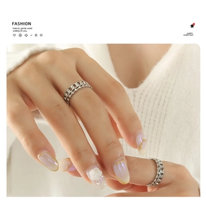 Nahaufnahme eines silbernen Doppelrings mit Panzerkette und Mikroperlen-Design am Finger