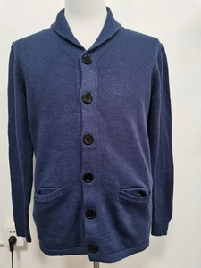 Detail of navy blue knit cardigan featuring a shawl collar and dark buttons on a mannequin