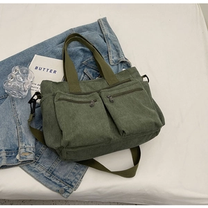 Detail of army green corduroy crossbody bag with double straps and dual front pockets