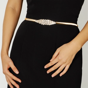 Detail of a golden spring waist chain with sparkling rhinestones on a black dress