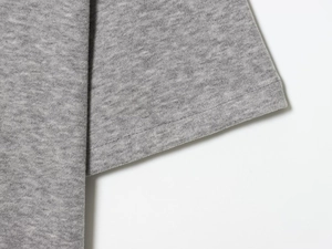 Detailed macro shot of grey knit fabric texture with professional double-stitched hem finish